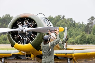 Business-savvy man working on an aircraft with a large propeller - make love not war