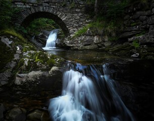 Fototapeta na wymiar Stunning landscape featuring a bridge crossing a cascading waterfall