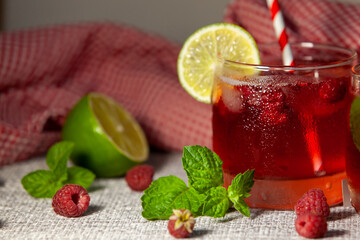 Homemade raspberry lemonade. Non-alcoholic cold drink in a misted glass. Selective focus.