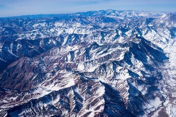 a long and large range of mountains are seen from a plane