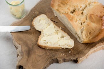 a sliced loaf of bread next to some butter on a cutting board