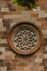 Vertical shot of an ornate window on a brick wall