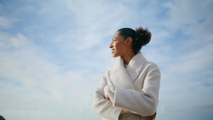 Cheerful woman spinning seashore at cloudy sky. Happy serene girl enjoying rest