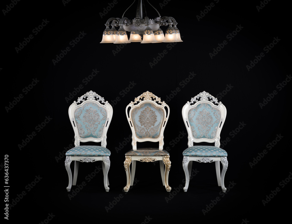 Sticker three vintage chairs and a chandelier in a black room