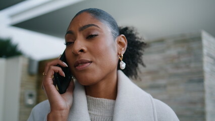 Attractive woman speaking smartphone on street closeup. Serious african american