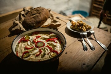 Closeup of a delicious meal with cucumbers on a rustic wooden table, served with a bread