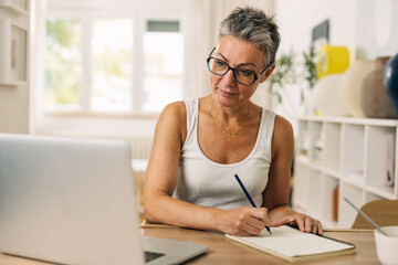 Mature woman is attending an online course.