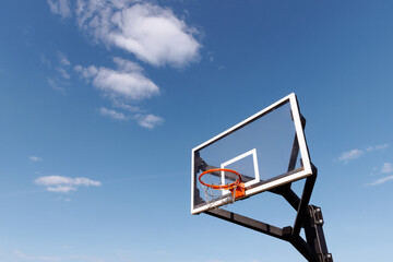 A new basketball hoop against a clear blue sky. The concept of urban sports. Ideal for conveying the excitement of outdoor play, sports catalogs and lifestyle publications.