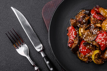 Delicious juicy fresh salad of baked eggplant, tomatoes, sweet peppers, sesame seeds