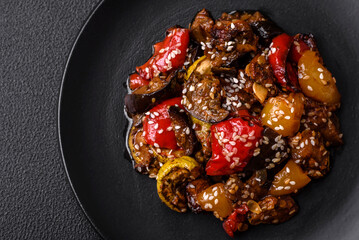 Delicious juicy fresh salad of baked eggplant, tomatoes, sweet peppers, sesame seeds
