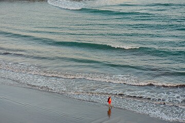 Aerial view of a person walking alone on the beach in Playa del Ingles, Maspalomas, Gran Canaria, Spain