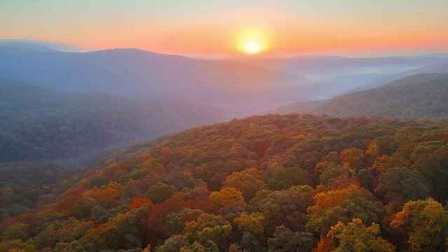 Colorful sunrise drone aerial over foggy autumn Arkansas ozark mountains with fall forest trees