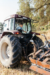 Woman on tractor in field in daylight