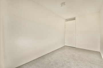 an empty room with white walls and no one door on the other wall there is a small window in the corner