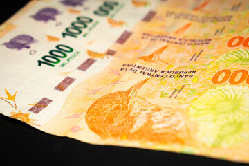 Banknotes of 1000 Argentine pesos, Argentine money, Argentine currency, Argentine pesos. Pile of several thousand Argentine peso bills, one thousand peso bills in cash on black background