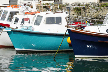 Colourful fishing boats moored at harbour of historical fishing village in Cornwall