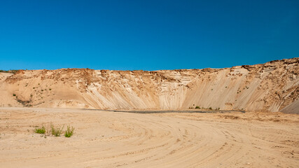 sand pit against the blue sky, forest in the background