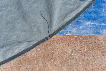 abstract synthetic material and dirt background (or gray and blue tarps and infield mix) at the...