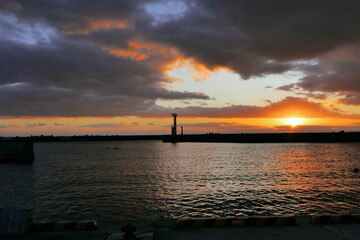 小さな灯台のある防波堤の夕日