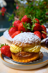 Tarte tropezienne or La Tarte de Saint-Tropez - dessert pastry consisting of filled brioche with cream and fresh berries served outdoor with fresh ripe strawberry