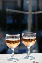 Pouring in glasses of cold rose Cote de Provence wine in yacht harbour of Port Grimaud, summer vacation on French Riviera Provence, France