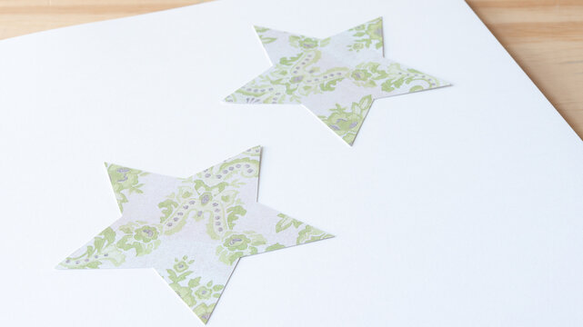 two soft-focused scrapbooking card stock stars with decor pattern on blank paper 