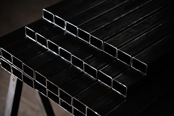 stack​ of square​ steel tubes​ profile or pipes for construction supplies and welding works