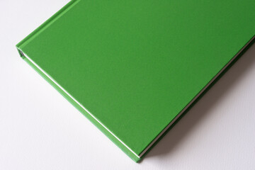 green covered book on blank paper