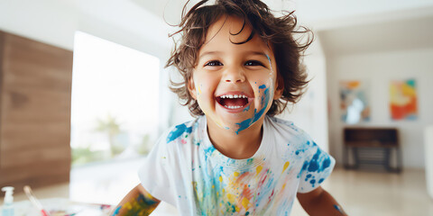 Happy European kid having fun playing with water color at home. Creative wallpaper, activity for...