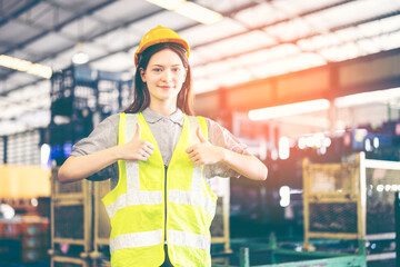 Factory female worker. Engineer woman worker working in plant production checking and testing machine in smart factory wearing yellow hard hat safety first at mechanic transportation factory.