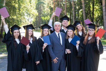 University professor and seven graduates rejoice at graduation. 