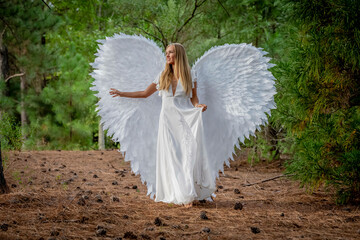 A Lovely Blonde Model Poses Outdoors While Wearing White Handmade Wings For Halloween