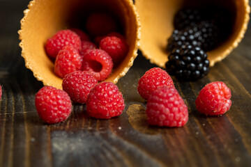 Ripe red raspberries in a crispy waffle cone