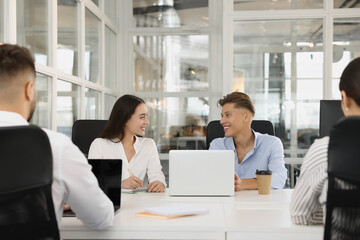 Colleagues working together in open plan office