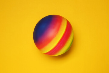New bright kids' ball on orange background, top view