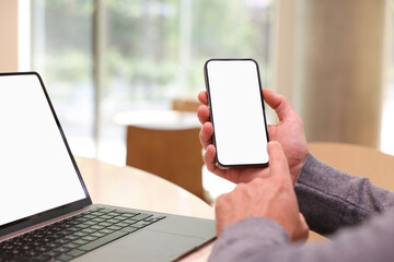 Man using smartphone at table in cafe, closeup