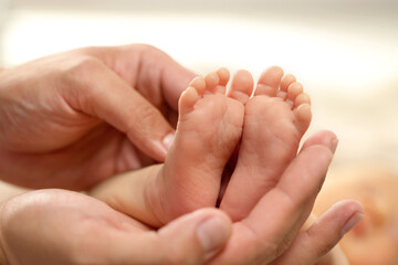 Father holding his newborn baby, closeup view on feet. Lovely family