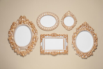Empty vintage frames hanging on beige wall