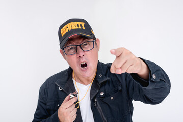 A strict and angry male security guard in his 40s berating someone. Pointing straight at camera. Isolated on a white background.