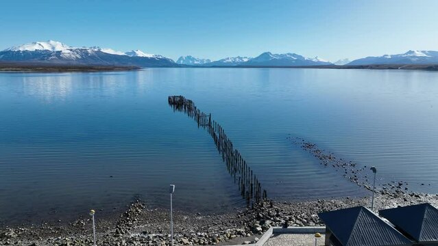 Pier Harbor At Puerto Natales In Ultima Esperanza Chile. Snowy Mountains. Bay Water Landscape. Ultima Esperanza Chile. River Background. Pier Harbor At Puerto Natales In Ultima Esperanza Chile.