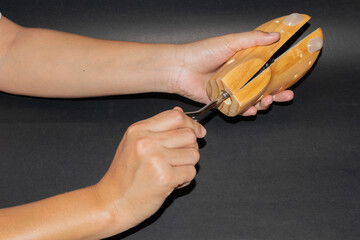 Skilled hands holding a shoe stretcher, showcasing expertise in footwear adjustment and care.