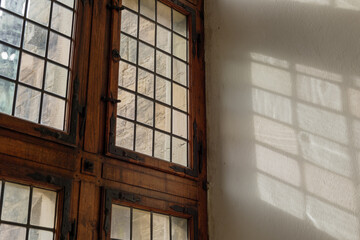Selective focus and interior view, light pass through old wooden window with rusty iron grid, shade and shadow.