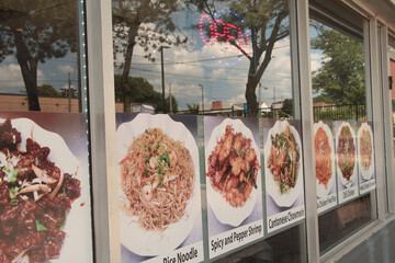 asian restaurant windows with neon open sign and pictures of meals dishes with caption writing beneath cantonese chowmein chicken fried rice chili chicken, entrance door, reflection sky trees