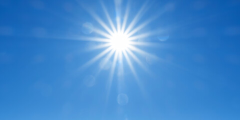 Naklejka na ściany i meble Panoramic sky background with radiant sun beams on bright blue sky