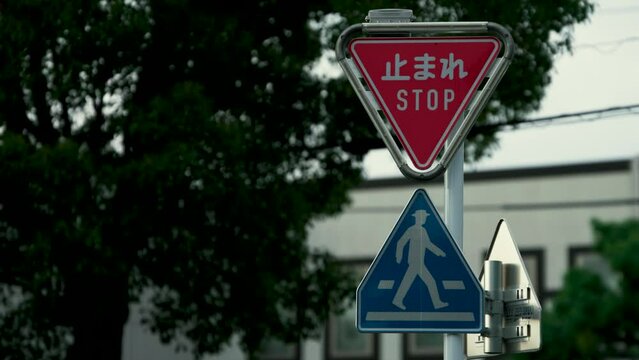 Tokyo, Japan - August 19, 2023: Stop road sign with blinking lights around
