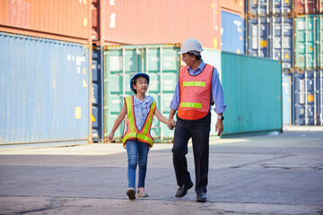 engineer or factory worker walking with her niece in containers warehouse storage