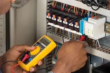 Electrician Checking Fuse Box With Multimeter