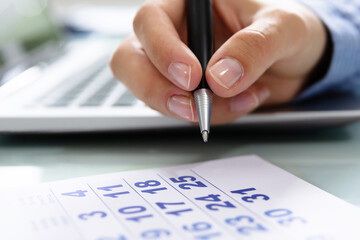 Businesswoman Marking Date On Calendar