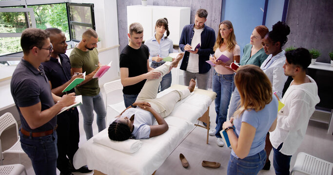 Male Instructor Teaching Massage Technique To Group