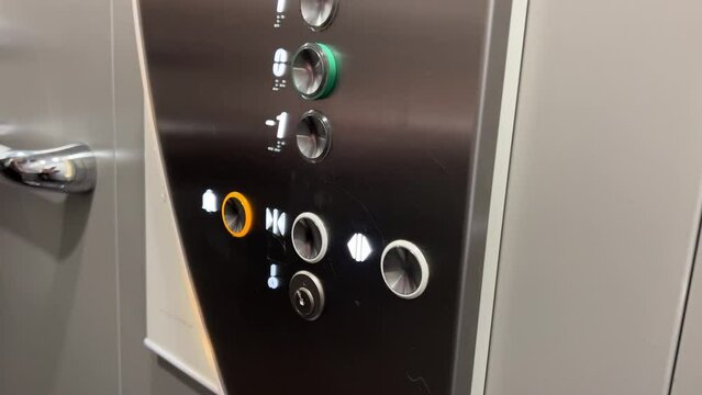 Caucasian hand rapidly pressing the close door button in an elevator. Impatient person in the lift.